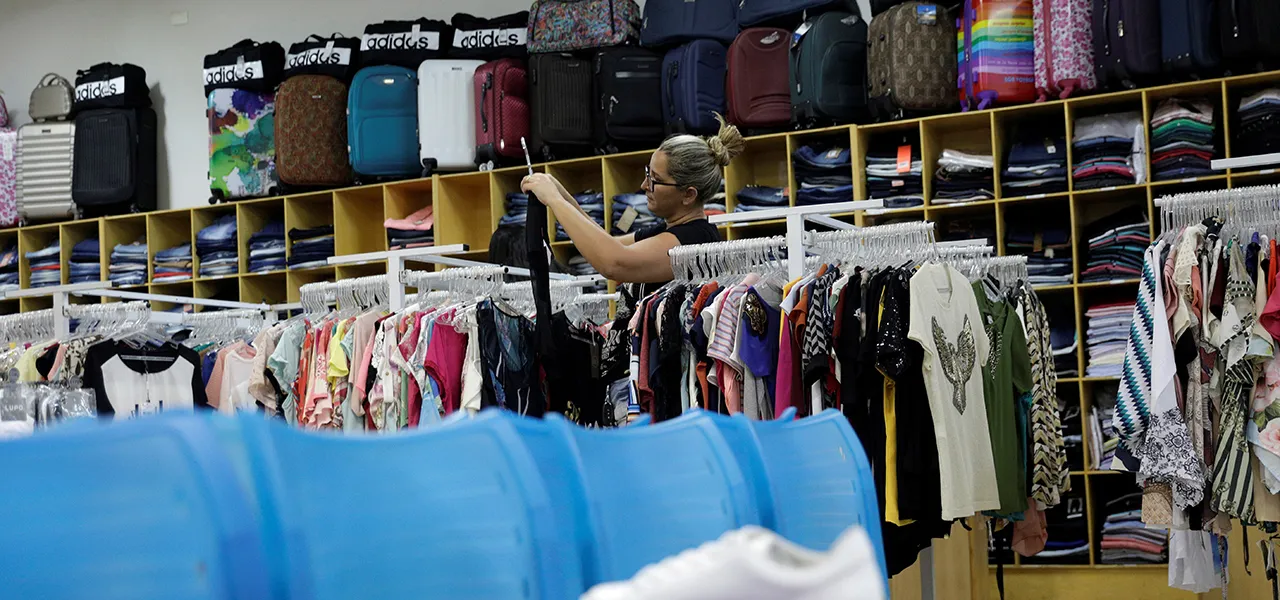 Araras com roupas em loja de vestuário brasileira, simbolizando o impacto da isenção fiscal sobre importados no varejo têxtil nacional