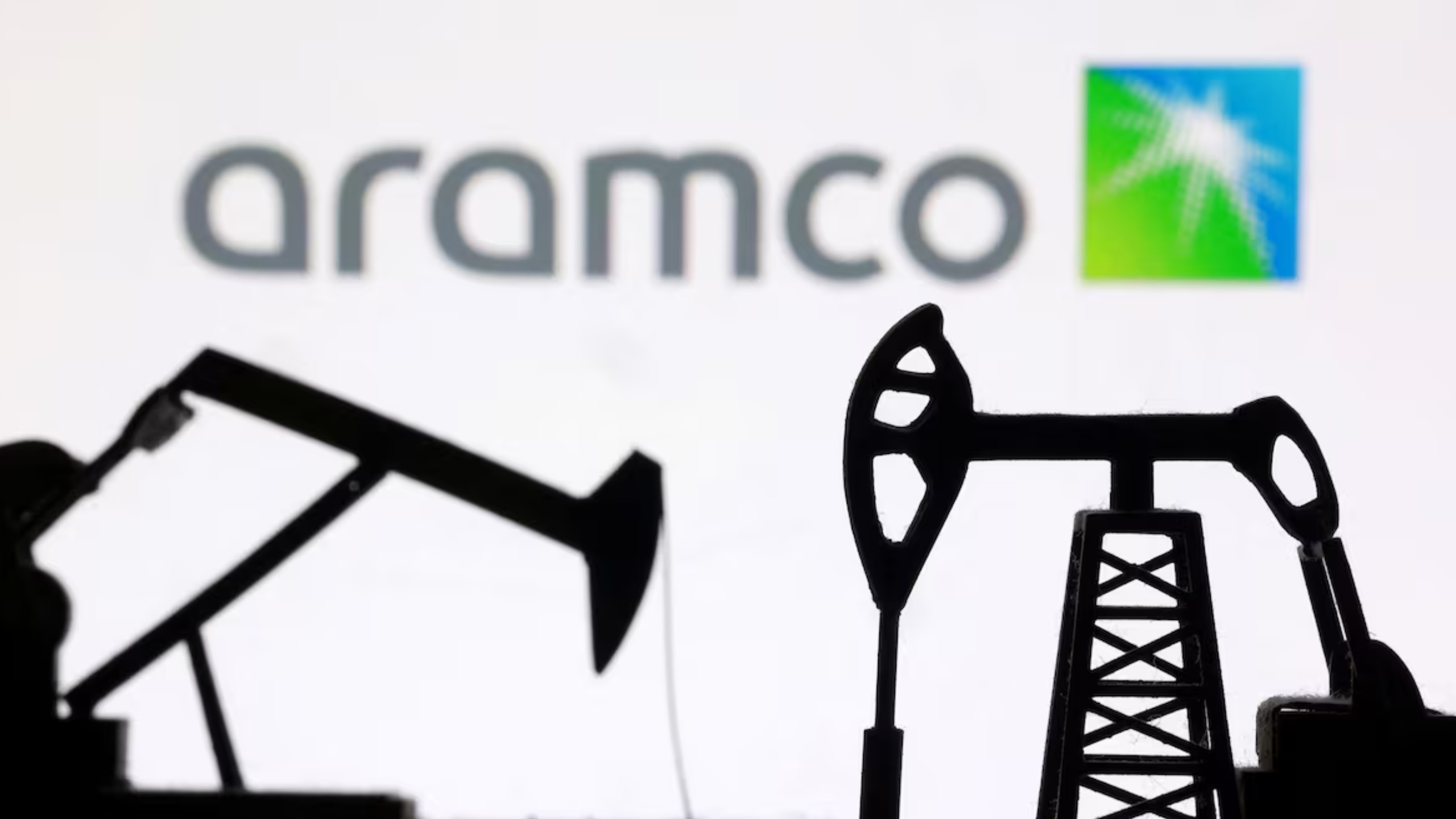 Coluna de fumaça preta e chamas visíveis sobre depósito de combustível da Aramco próximo ao Aeroporto Internacional de Riad, com viaturas de bombeiros ao fundo