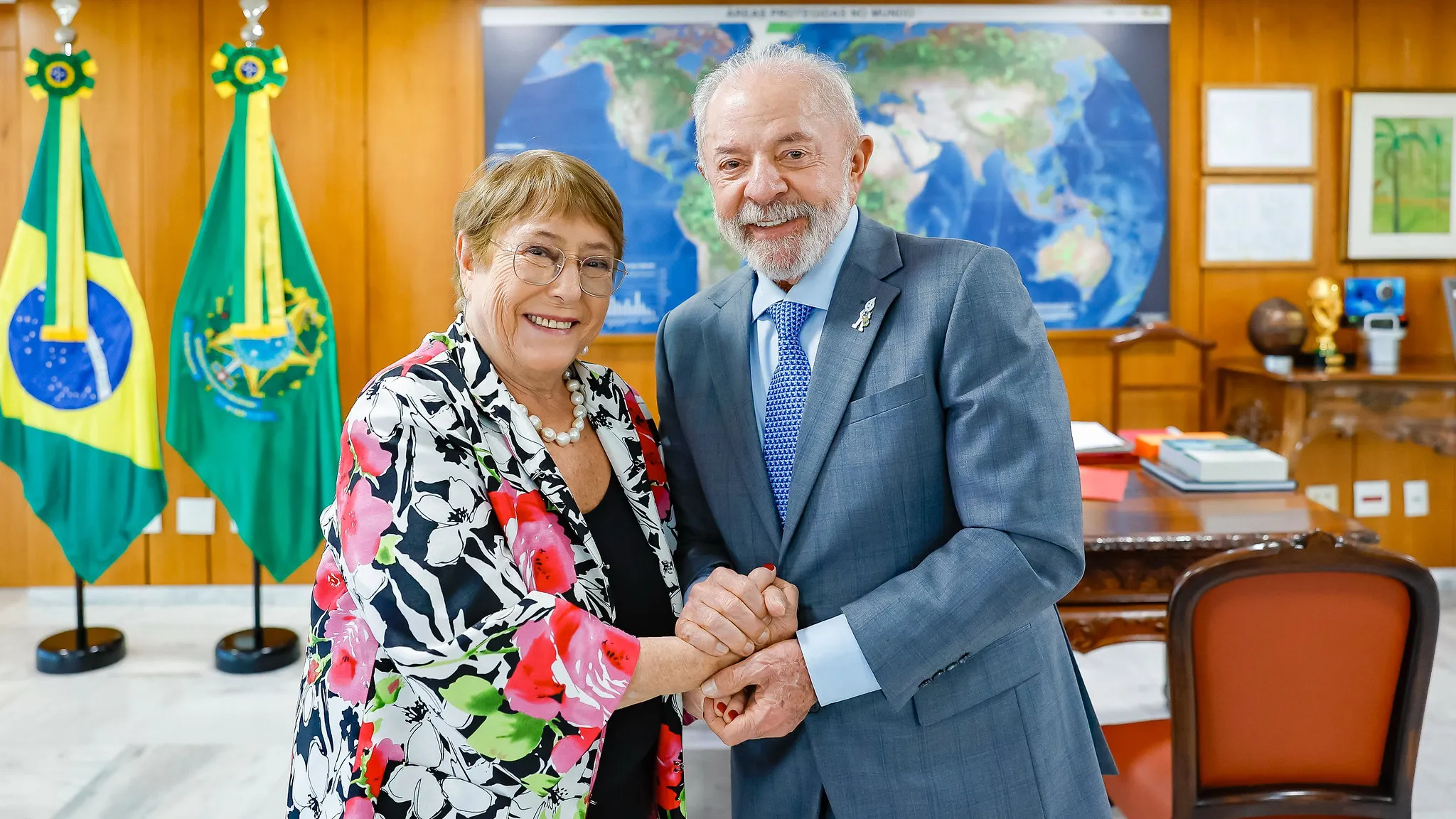 Michelle Bachelet, ex-presidente do Chile, em tribuna oficial; ao fundo, bandeiras da ONU representando a candidatura latino-americana retirada da disputa pela Secretaria-Geral