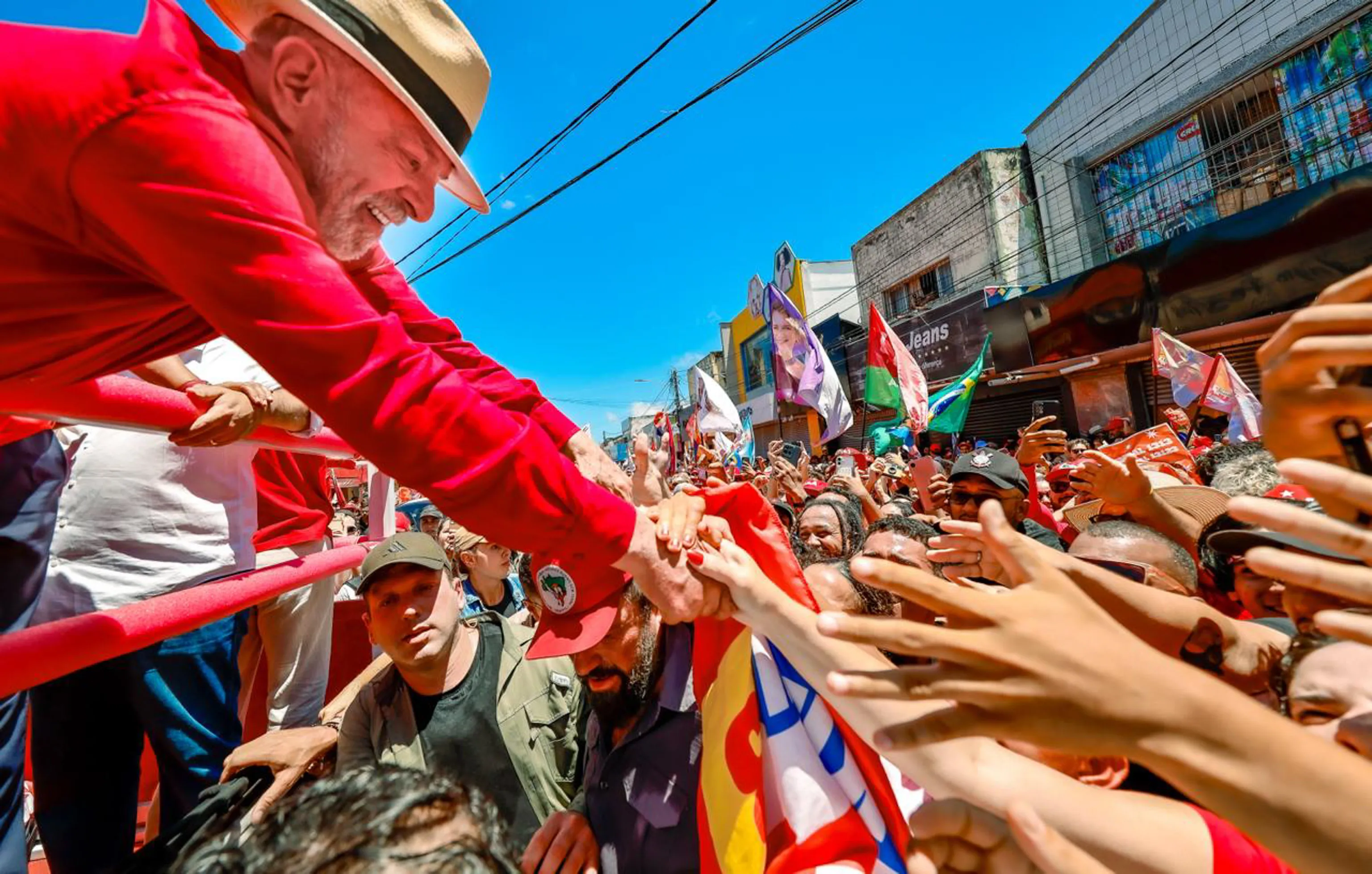 Jovens estudantes em manifestação de rua segurando faixas em apoio ao presidente Lula, com expressão de engajamento político e mobilização coletiva