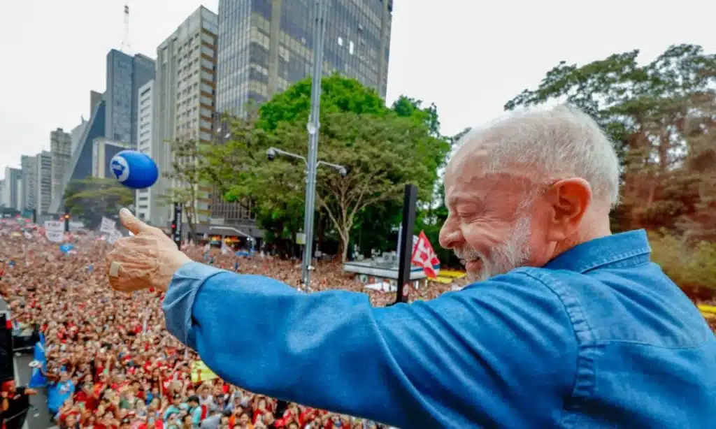 Multidão de manifestantes pró-Lula ocupa a Avenida Paulista em São Paulo durante a Marcha pela Democracia, com faixas e bandeiras coloridas ao longo de 10 quarteirões