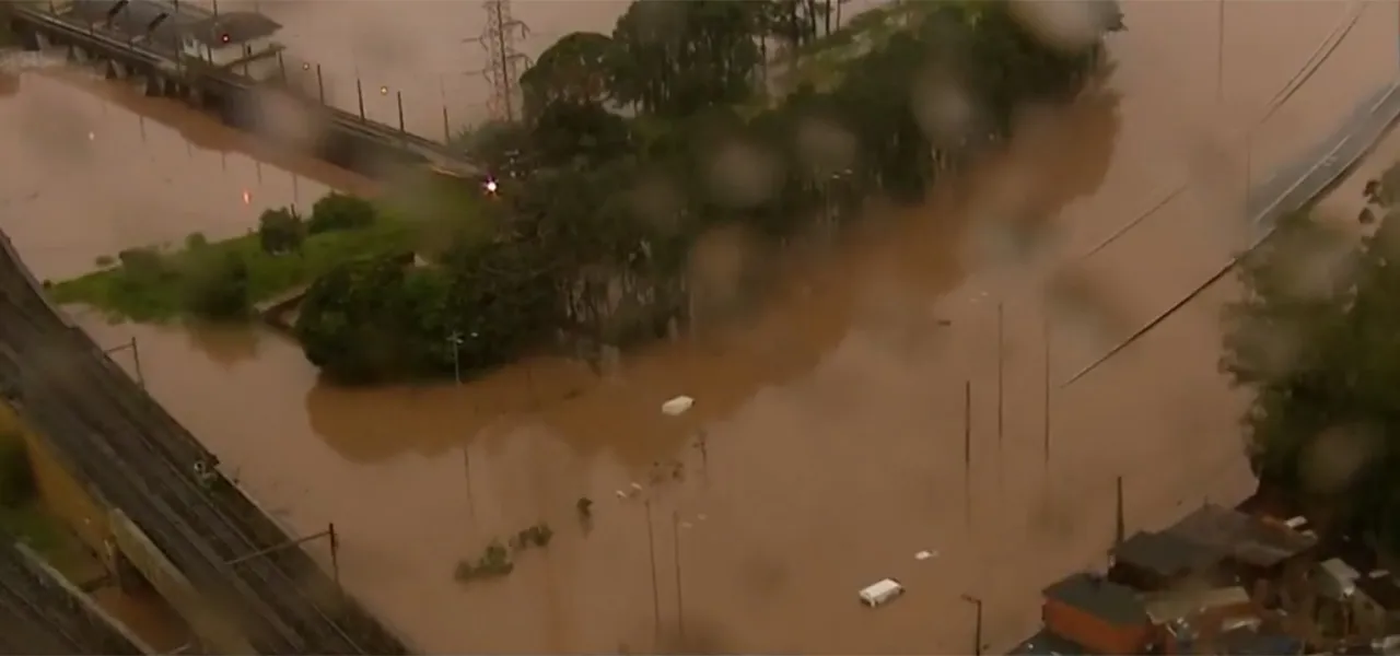 Carros submersos dentro do túnel do Vale do Anhangabaú em São Paulo durante alagamento causado por tempestade, com pessoas ilhadas sobre os veículos