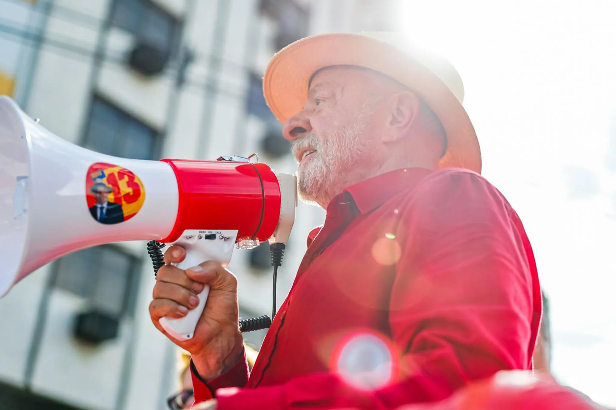Presidente Lula discursa em palanque durante ato político em Ipatinga, Minas Gerais, com bandeiras do PT ao fundo, alertando trabalhadores sobre riscos de vitória da direita nas eleições