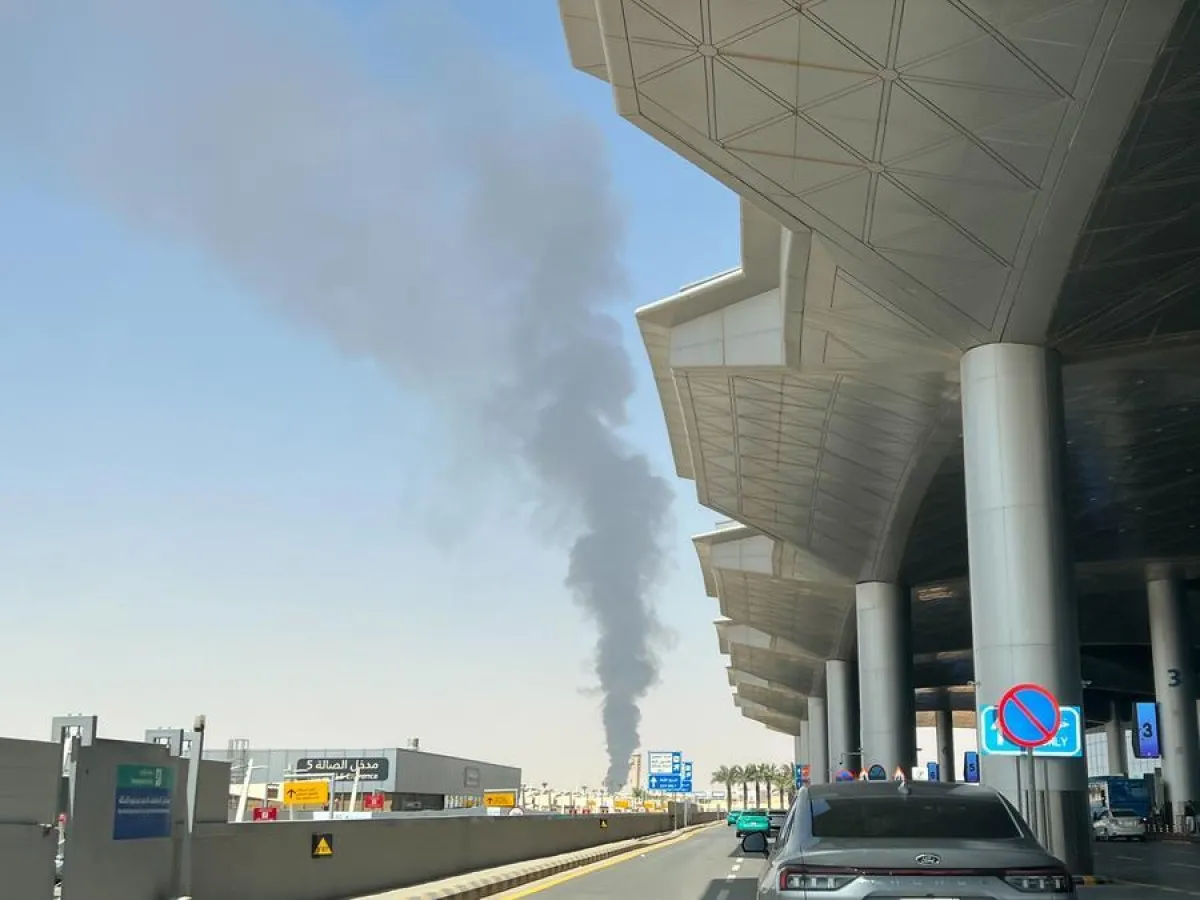 Aeronave comercial sobrevoando região do Oriente Médio com fumaça ao fundo simbolizando conflito armado envolvendo ataques Houthis à aviação civil saudita