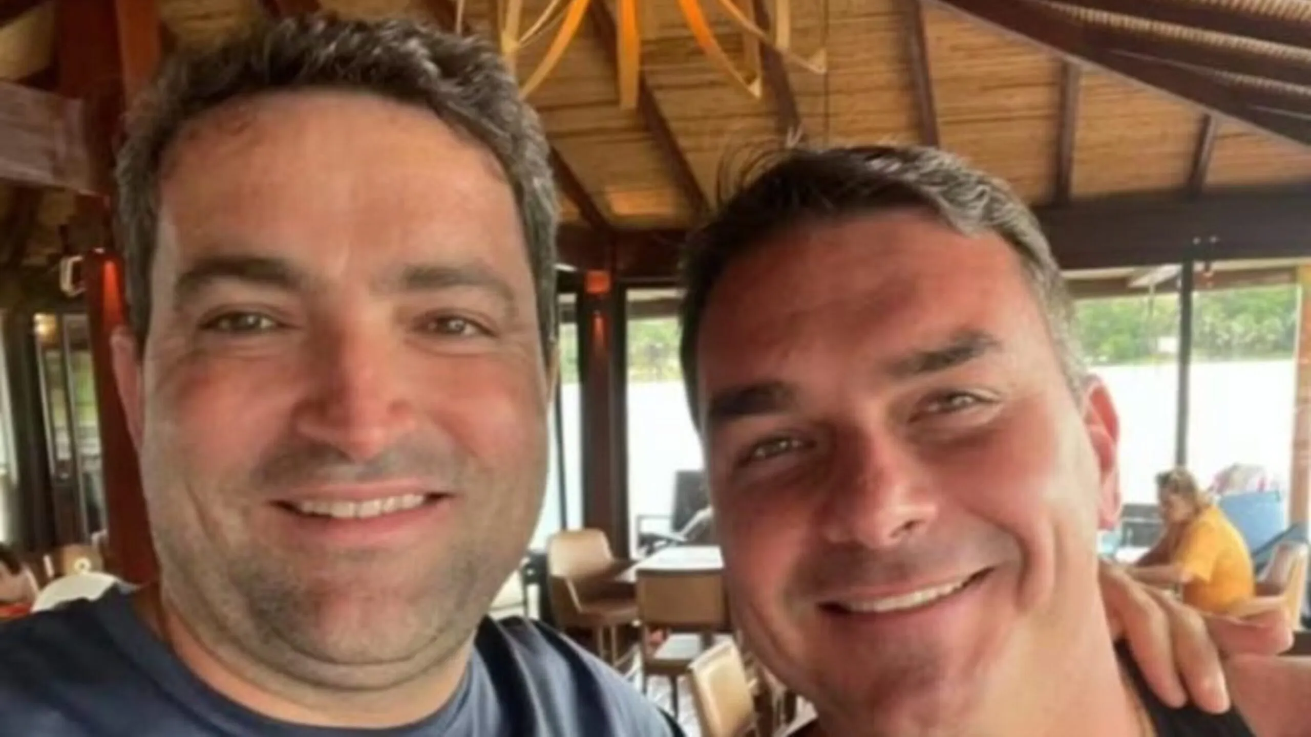Senador Flávio Bolsonaro em sessão no Congresso Nacional, ao fundo o brasão da Polícia Federal