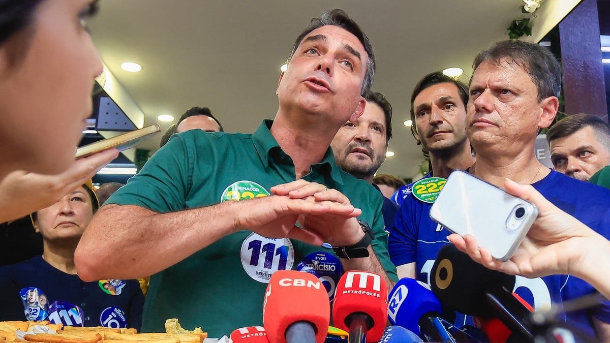Imagem ilustrativa de uma urna eletrônica e cédulas de votação em uma seção eleitoral, representando a fiscalização do processo de votação no segundo turno.